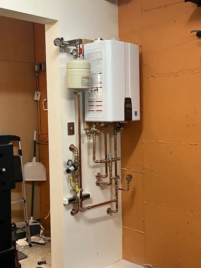Plumbing technician inspecting water heater connections in Alameda